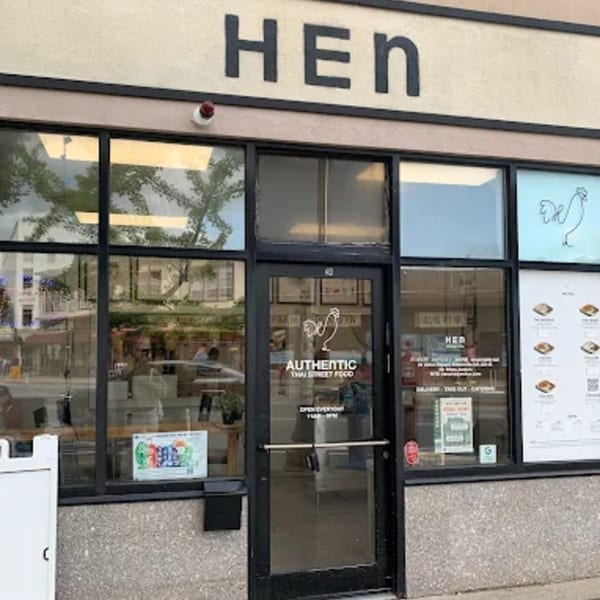 Exterior of Hen Thai restaurant with large windows, a glass door, and a sign above.