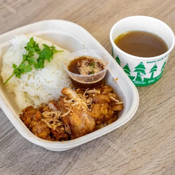 Thai fried chicken with rice, cilantro, dipping sauce, and a cup of broth.